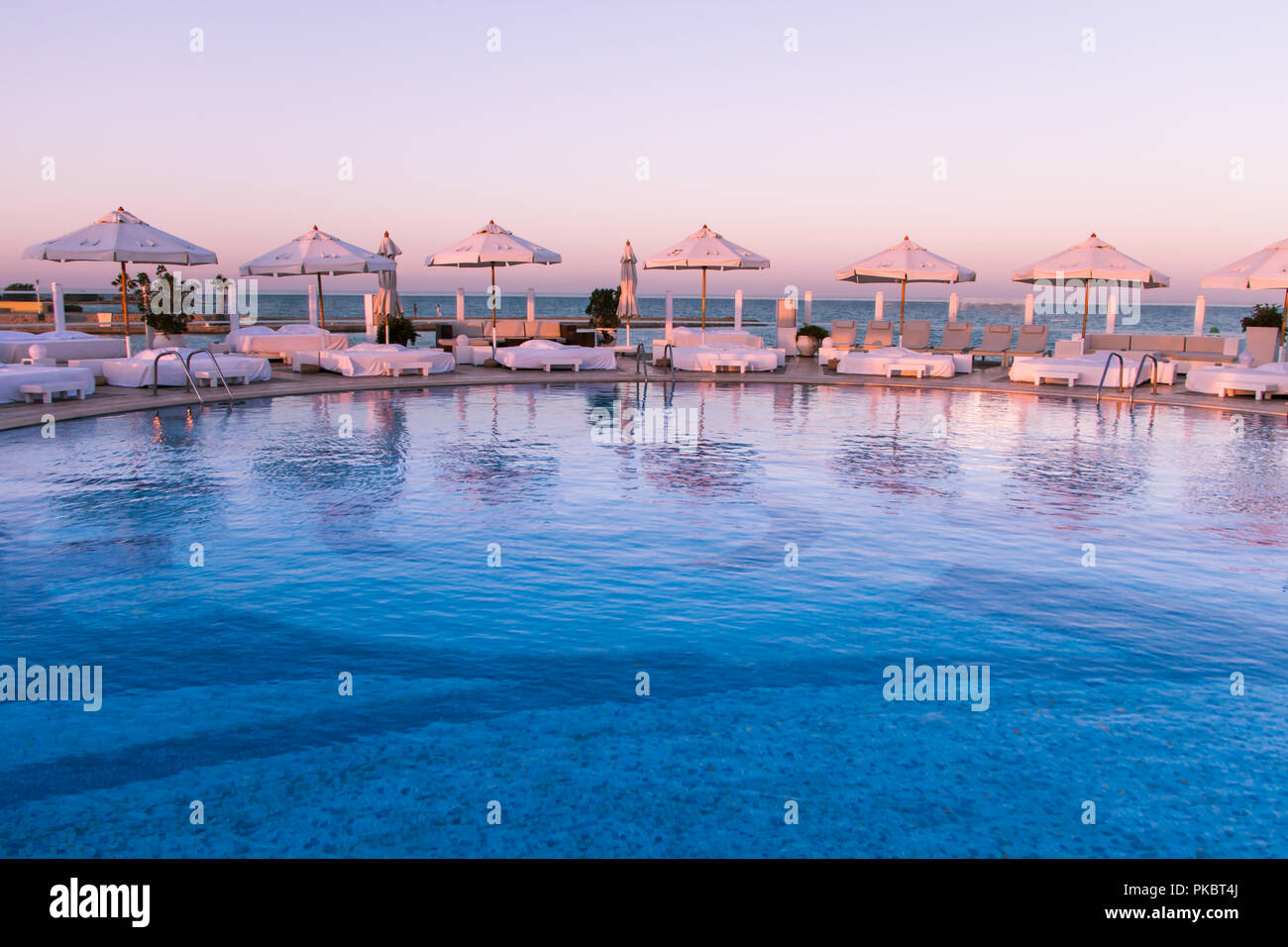 Coucher de soleil Pastel Lumière sur piscine et bains de soleil Banque D'Images