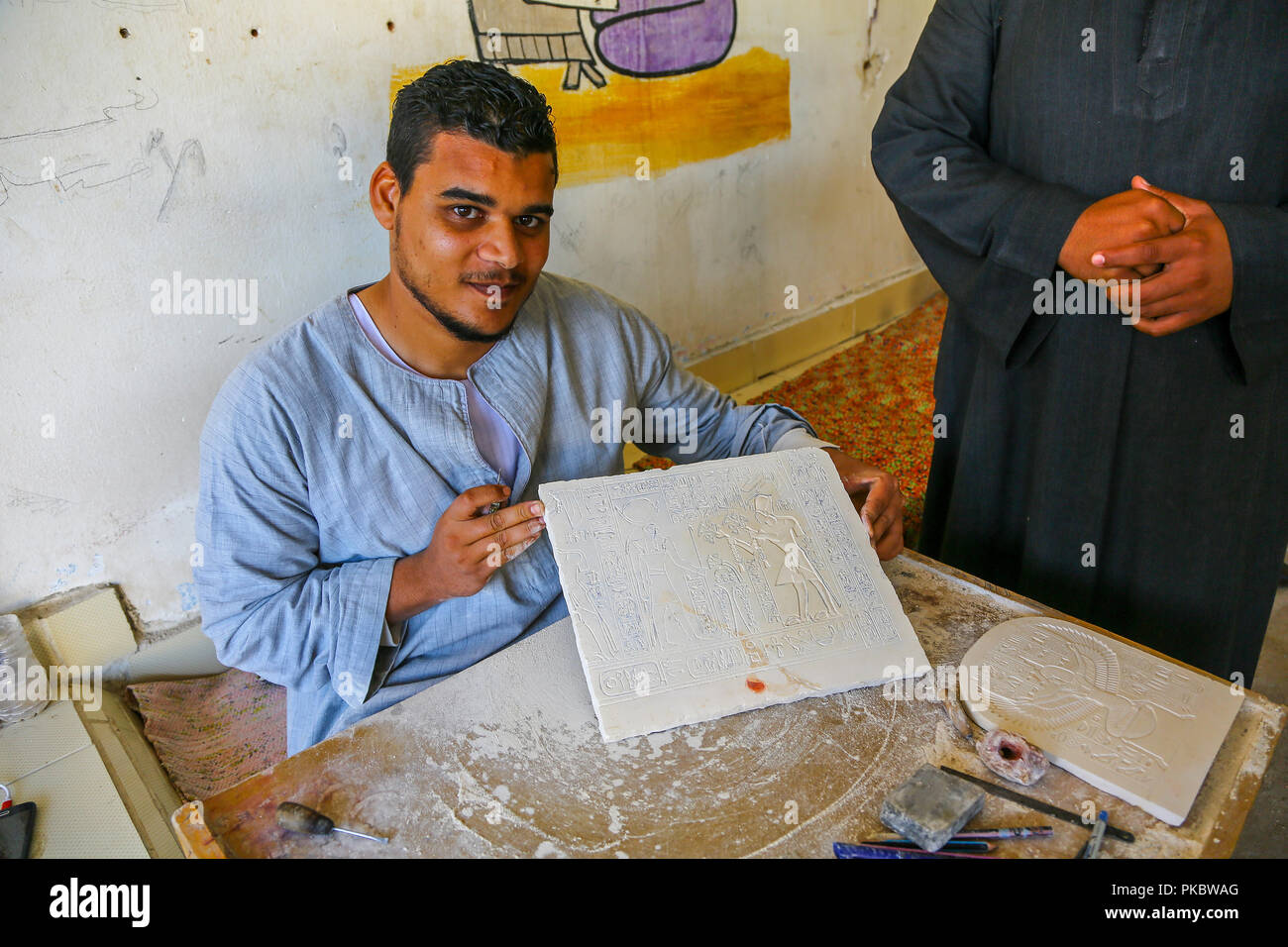 Un artisan qualifié montrant qu'il a fait sculpter une plaque de calcaire à une usine de fabrication et de l'albâtre en Egypte, l'Afrique Banque D'Images