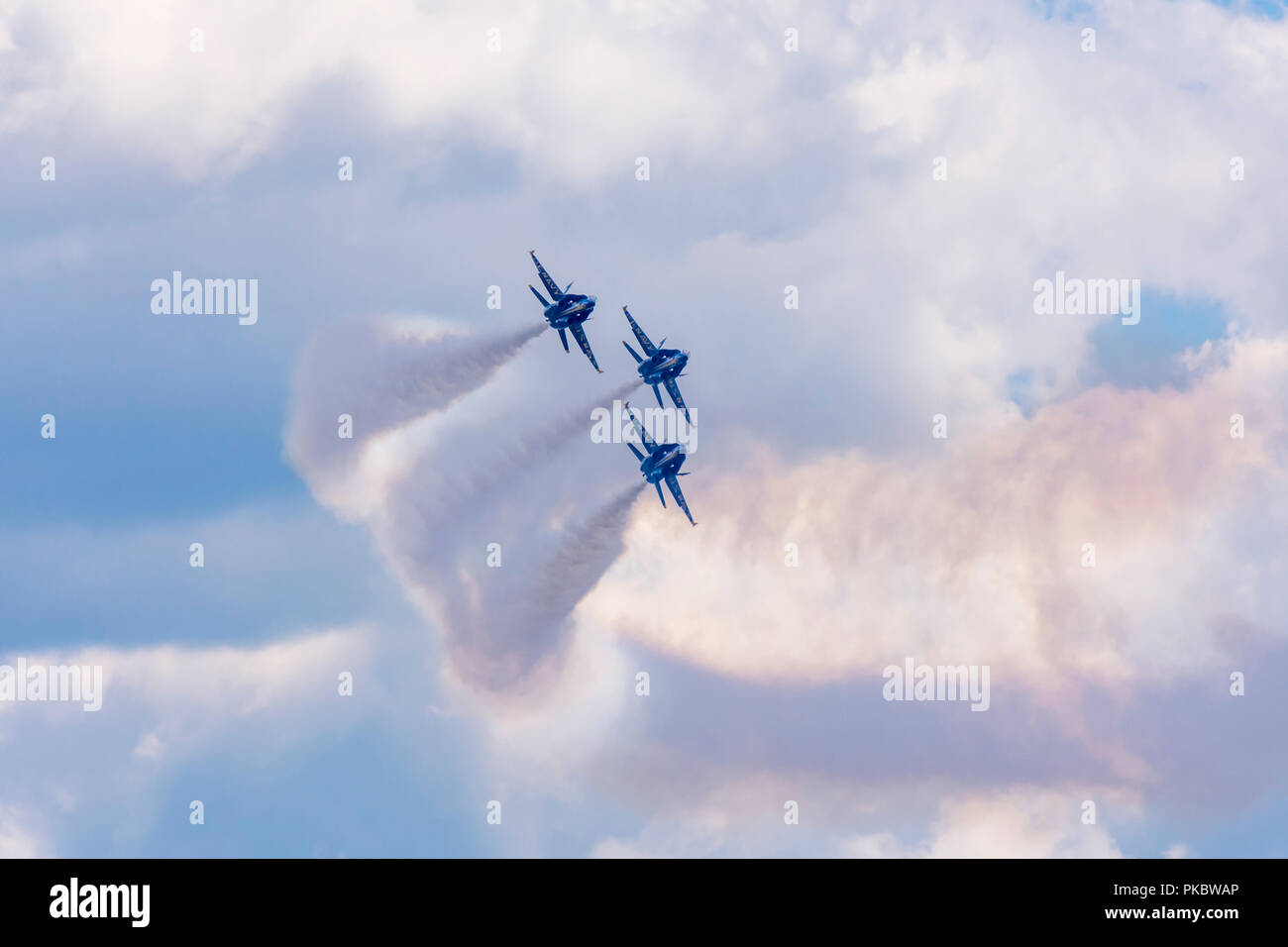 Trois jets F/A-18 Hornet de l'escadron de démonstration de vol de la Marine des États-Unis, les Blue Angels volent en formation étroite contre un ciel nuageux. Banque D'Images