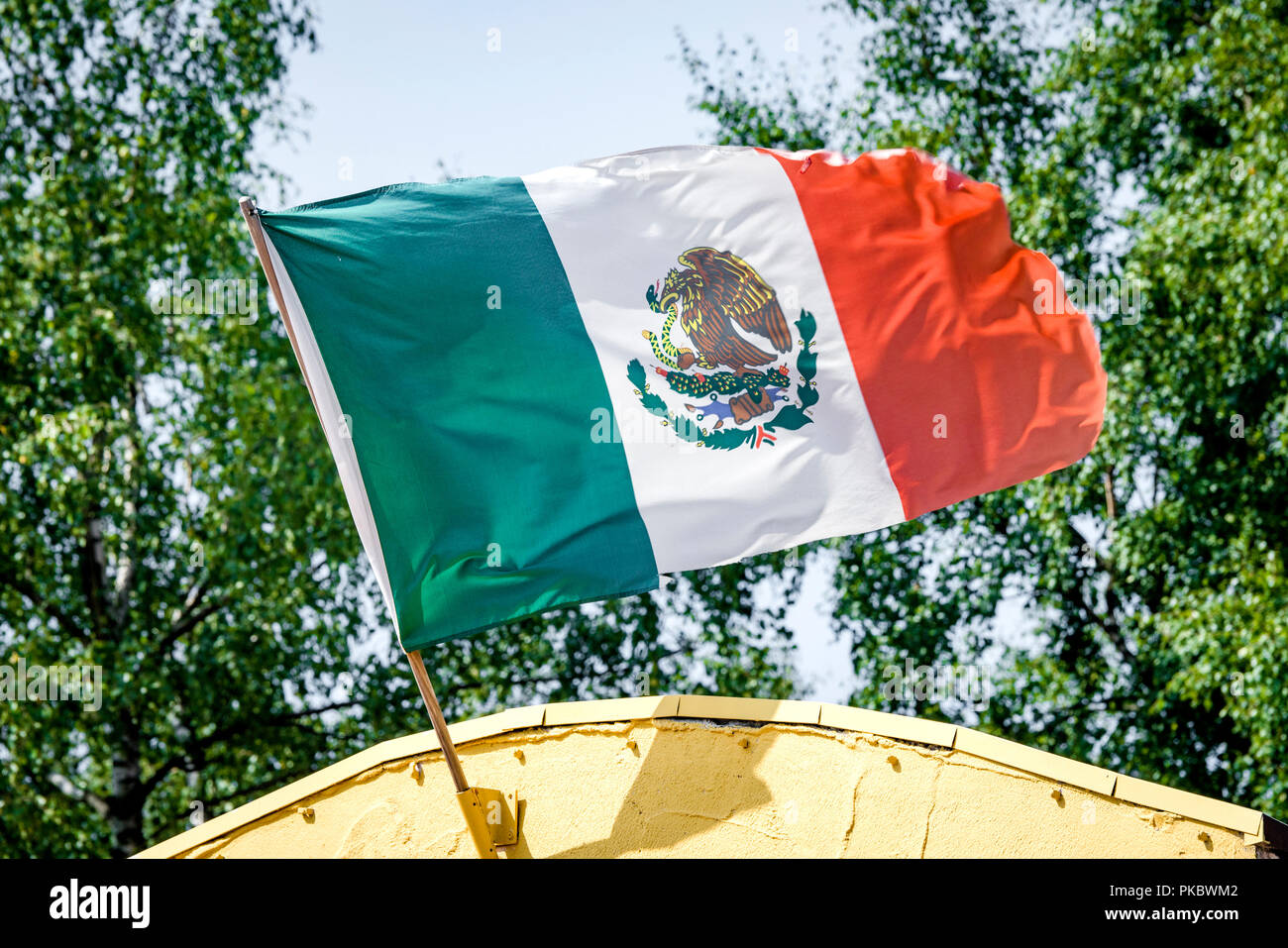 Drapeau Mexicain sur un bâtiment jaune forme dans le vent au Mexique Banque D'Images