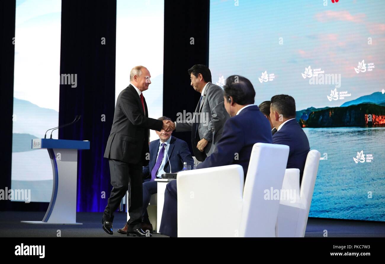 Le président russe Vladimir Poutine se félicite le Premier ministre japonais Shinzo Abe à la session plénière du 4ème Forum économique de l'est le 12 septembre 2018 à Vladivostok, en Russie. La session a exploré l'Extrême-Orient : l'élargissement de l'éventail des possibilités. Banque D'Images