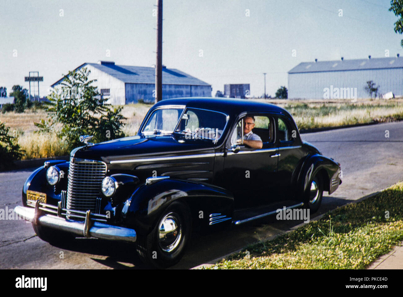 Chrome et noir 2 portes berline Cadillac vieille voiture américaine avec une plaque de la Californie de 1956. Image prise en 1962 Banque D'Images