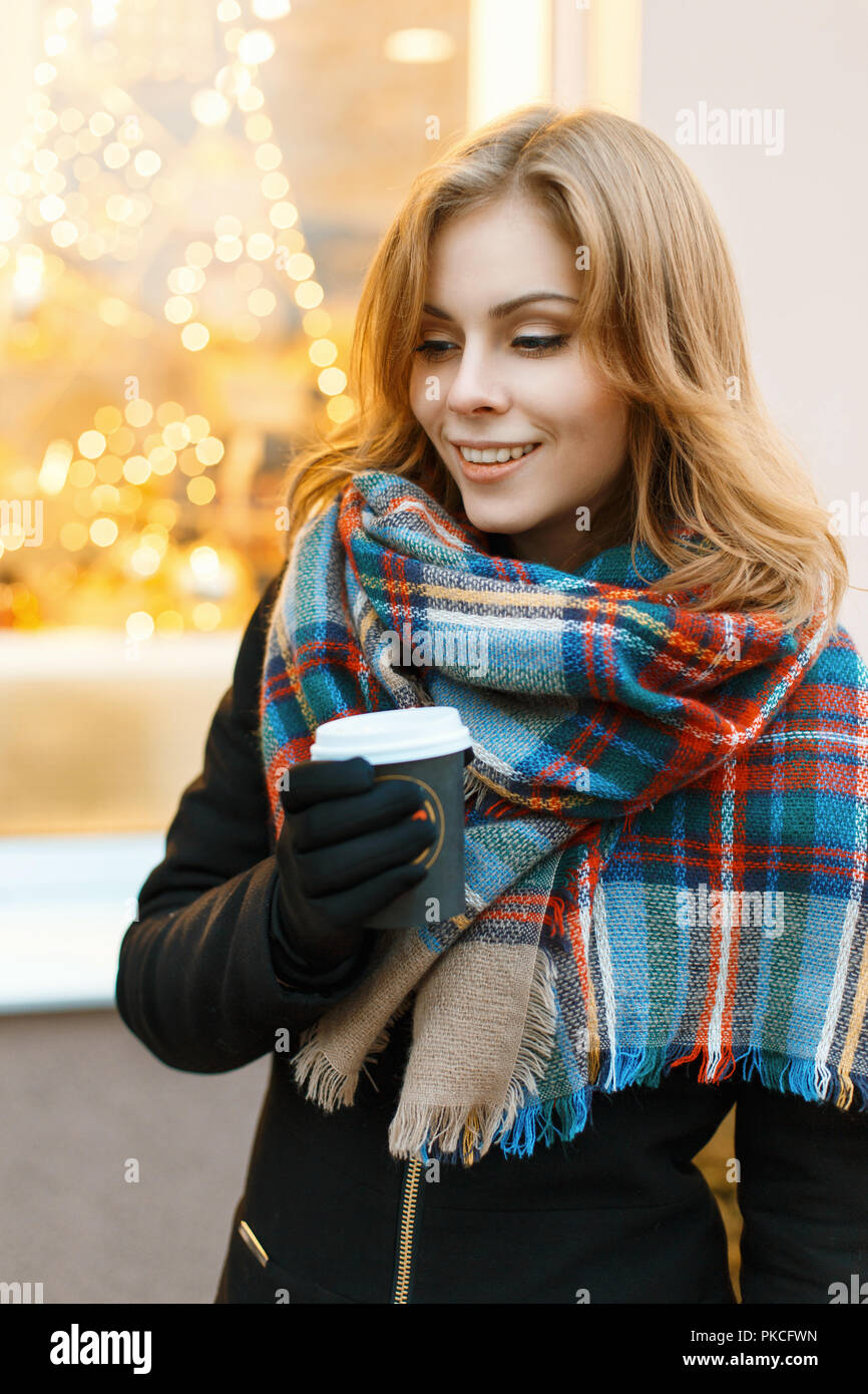 Jolie femme avec un sourire dans une élégante Écharpe et manteau noir  balade et boire un café chaud dans une journée d'hiver Photo Stock - Alamy