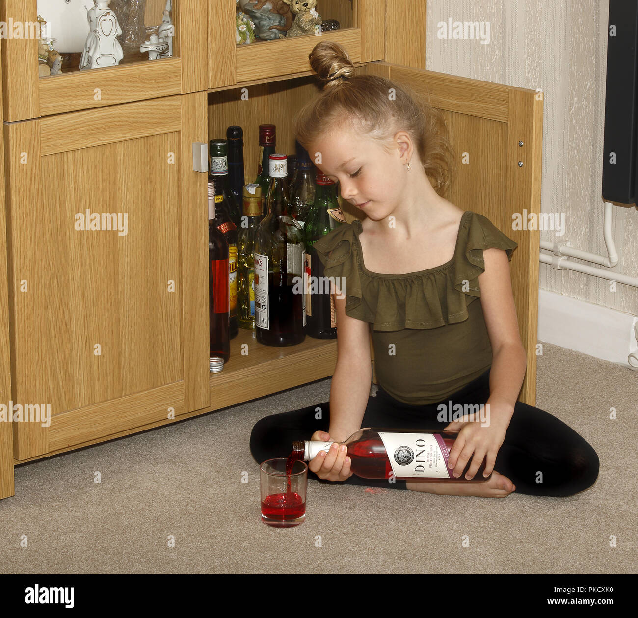 Une fillette de six ans d'aider elle-même à du vin d'un bar Banque D'Images