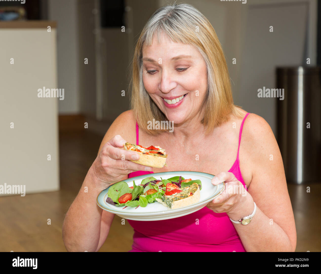 Femme mangeant un repas salade et quiche Banque D'Images