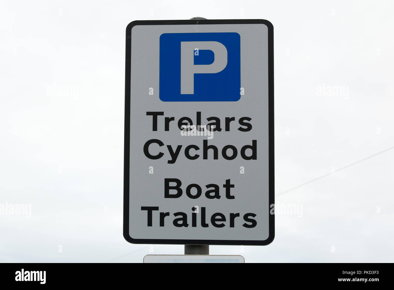 Parking pour la langue galloise (Trelars Cychod remorques bateaux) signe avec le texte noir sur fond blanc avec parking P bleu ciel blanc clair contre symbole Banque D'Images