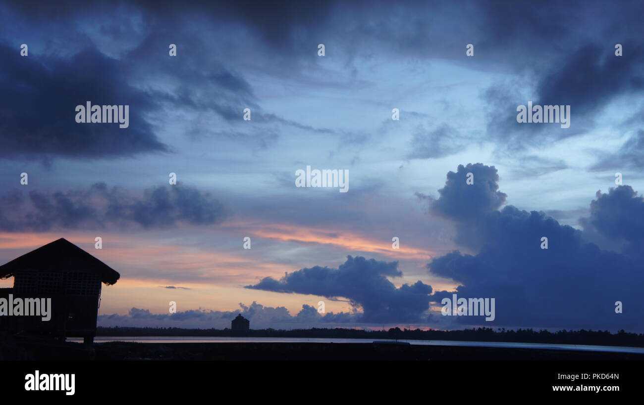 Silhouette d'un Nipa Hut le long de la baie en attendant le lever du soleil Banque D'Images