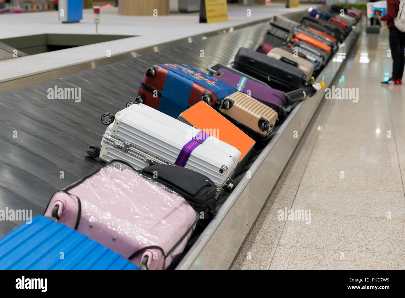 Valise ou assurance avec courroie de transport à l'aéroport. Attente Traverler valise ou bagages dans le hall d'arrivée à l'aéroport. Banque D'Images