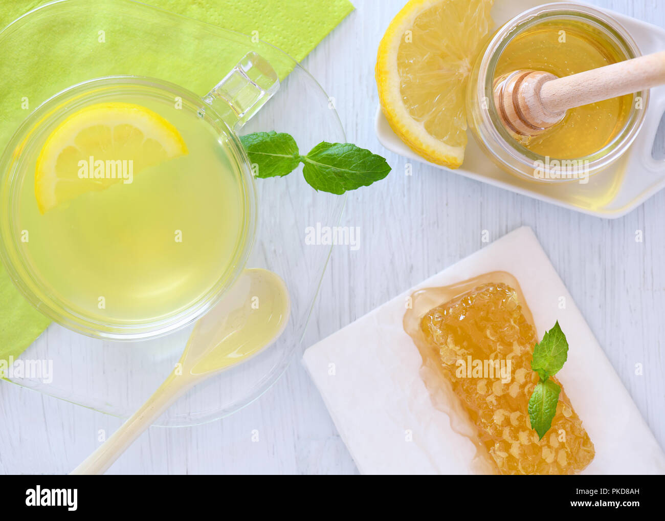 Plus colorés head shot de miel et citron boisson chaude montrant le miel-cone, fond bleu tranche de citron et de menthe fraîche copyspace Banque D'Images