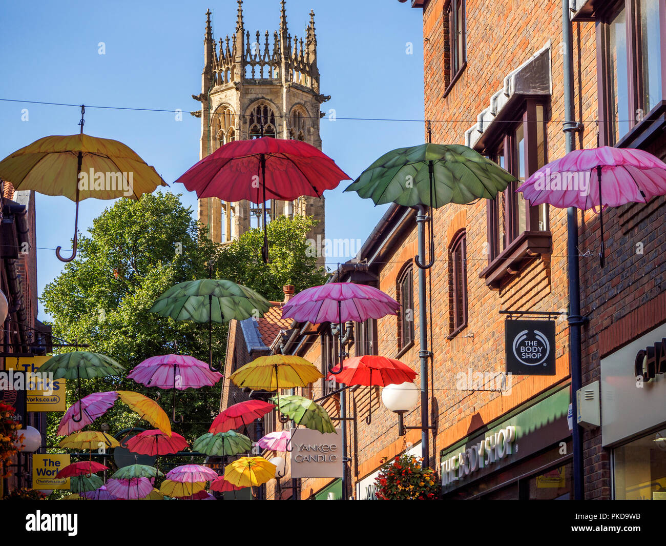 L'ensemble de parasols colorés Coppergate avec tous les saints de l'église chaussée tour derrière York Yorkshire Angleterre Banque D'Images