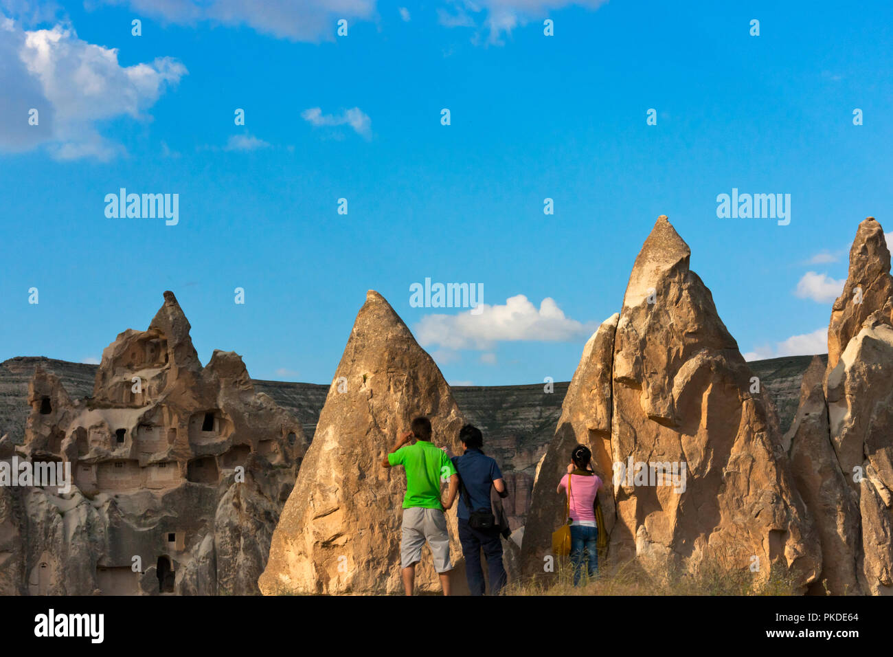 Les touristes regardant des maisons creusées dans les formations rocheuses de la vallée de Goreme, Cappadoce, Turquie (site du patrimoine mondial de l'UNESCO) Banque D'Images