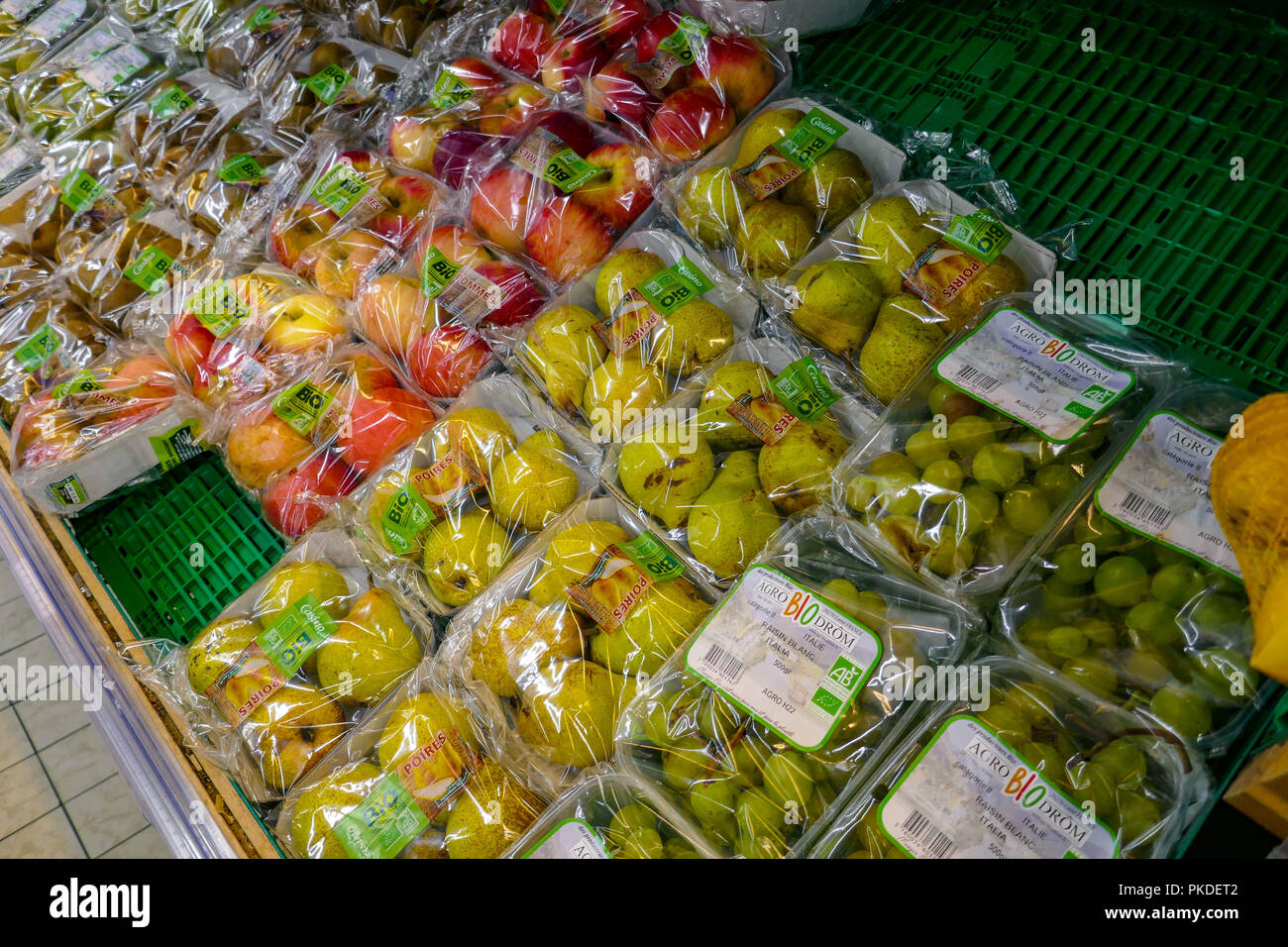 Les pommes, poires, raisins, fruits emballés dans du plastique dans un supermarché français Banque D'Images