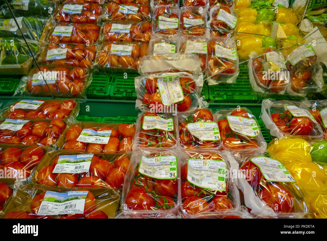 Les tomates et les poires, les fruits présentés en plastique dans un supermarché français Banque D'Images