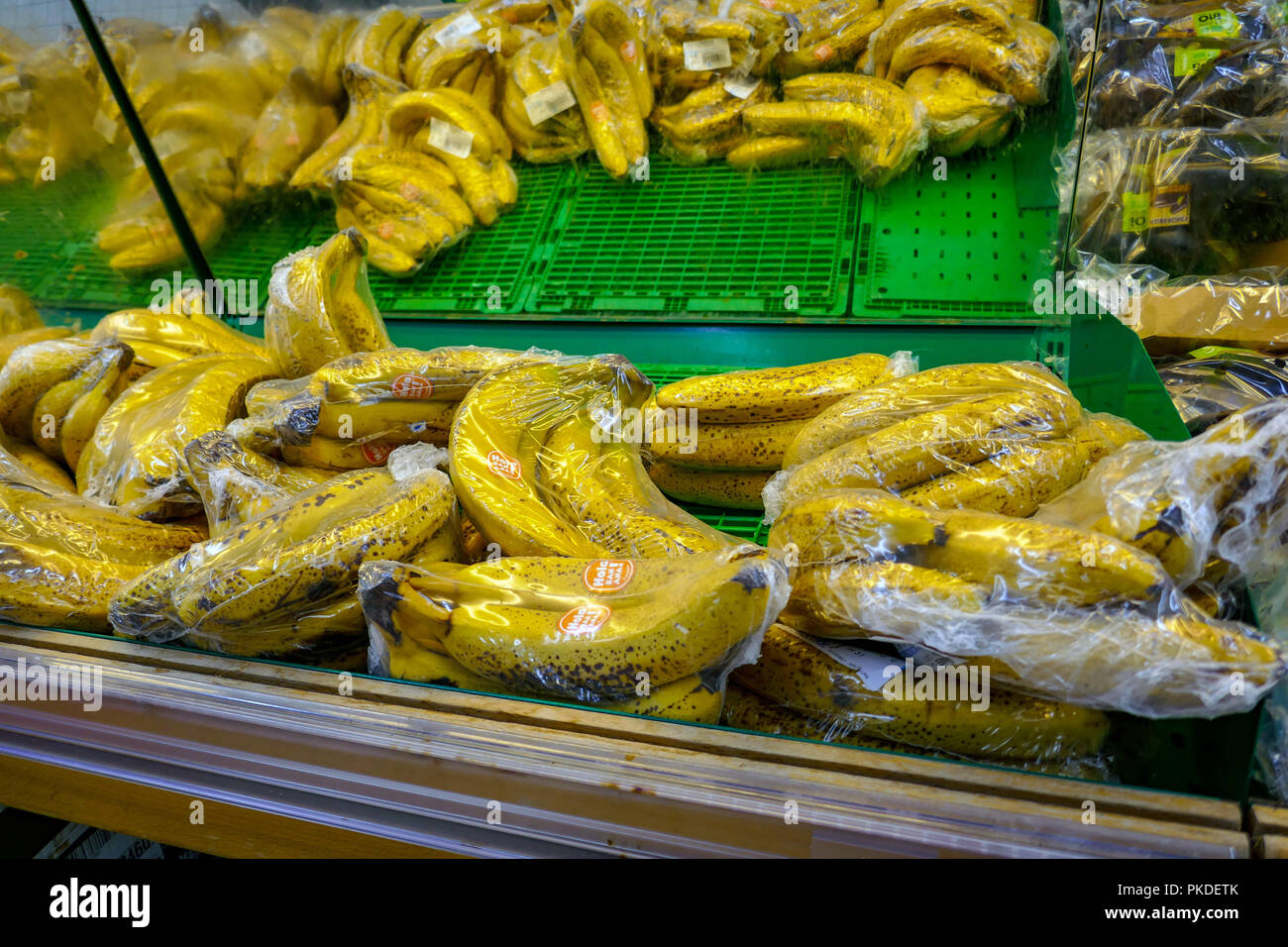 Les bananes, les fruits présentés en plastique dans un supermarché français Banque D'Images