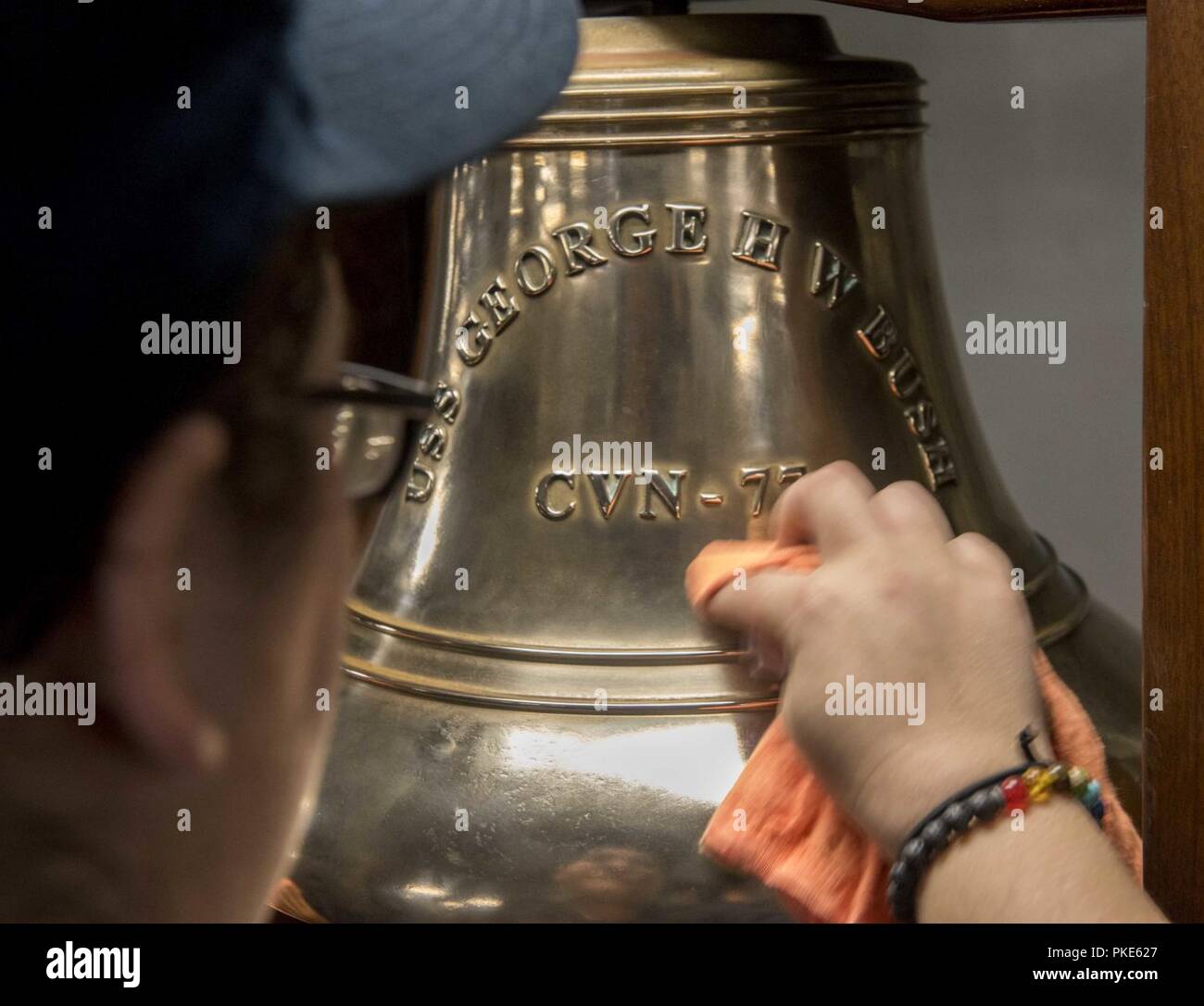 NORFOLK, Virginie (25 juillet 2018) Maître de Manœuvre Seaman Mariah Juber, de Bethel, Vermont, brille la cloche du navire au cours du poste de nettoyage à bord du porte-avions USS George H. W. Bush (CVN 77). Le bateau est dans le port de Norfolk, Virginie, en effectuant des exercices d'entraînement de routine pour maintenir l'état de préparation de l'opérateur. Banque D'Images