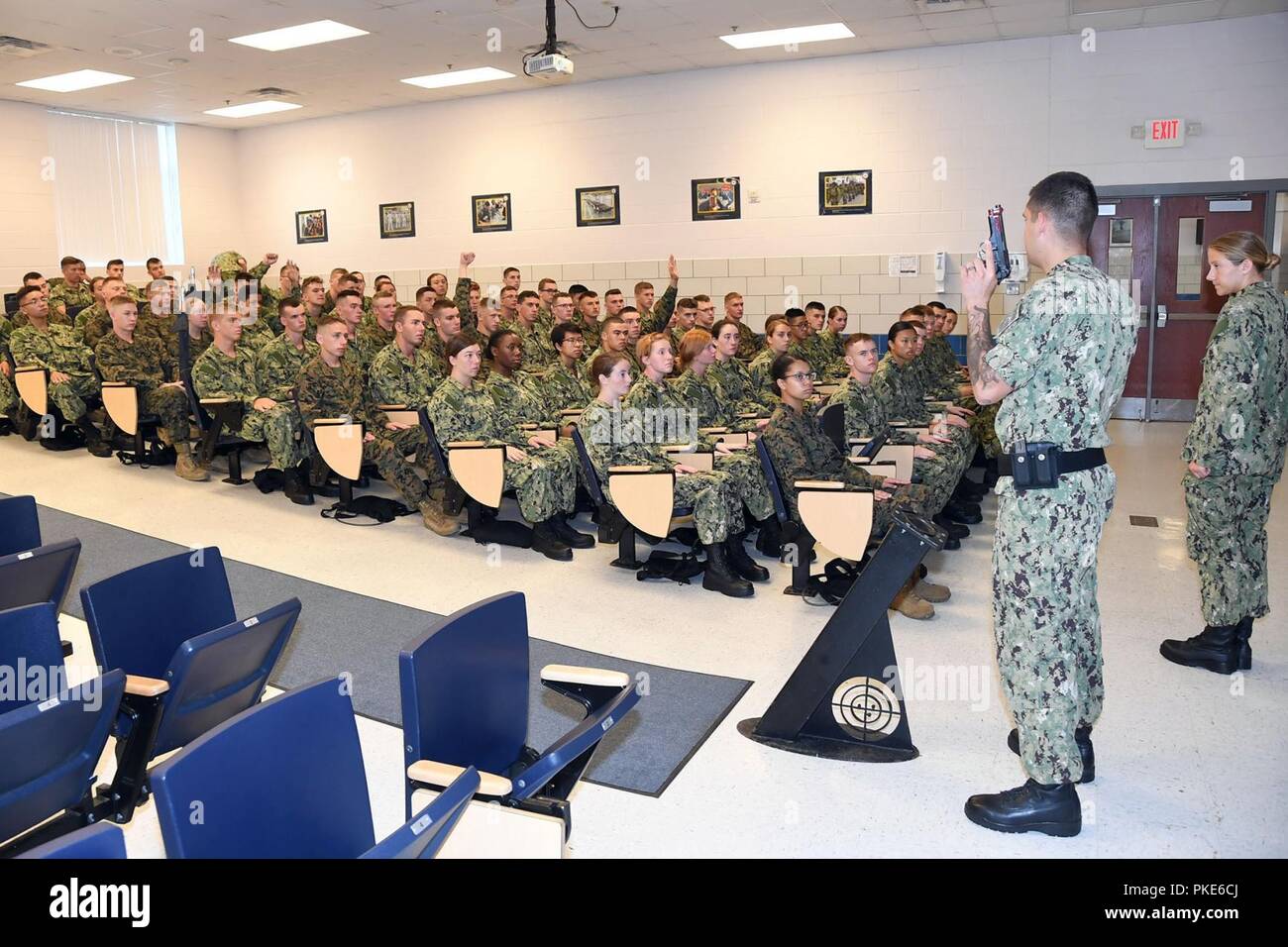 Lacs, en Illinois (24 juillet 2018) 4400 Machiniste sous-marin (Armes) 1re classe Blairhandzel Jacob, un facilitateur dans le tir de petit calibre USS Missouri formateur à recruter le commandement de l'instruction (RTC), indique à l'aspirant de ROTC Naval candidats comment pour gérer correctement un Beretta M9 9mm pistolet. Plus de 65 jeunes hommes et femmes dans leur première année du programme NROTC a participé à un programme pilote de deux semaines visant à standardiser la militarisation d'entrée de gamme et préparer les aspirants à une politique commune de l'orientation de la formation. La croisière d'endoctrinement sert de point de lancement de la formation standard Banque D'Images