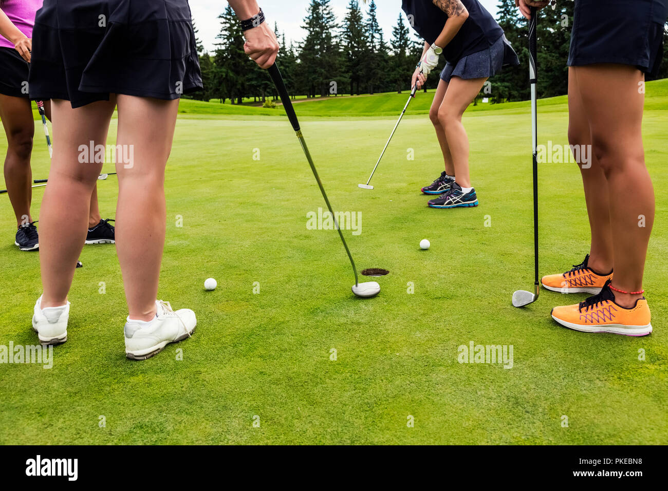 Un quatuor de golfeuses sur un green à tour de mettre en utilisant la meilleure balle dans un Texas scramble lors d'un tournoi Banque D'Images