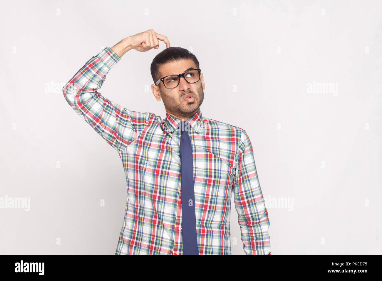 Portrait of handsome businessman barbus en chemise à carreaux colorés,  cravate bleue et lunettes et permanent à la voiture avec drôle de visage.  en Photo Stock - Alamy