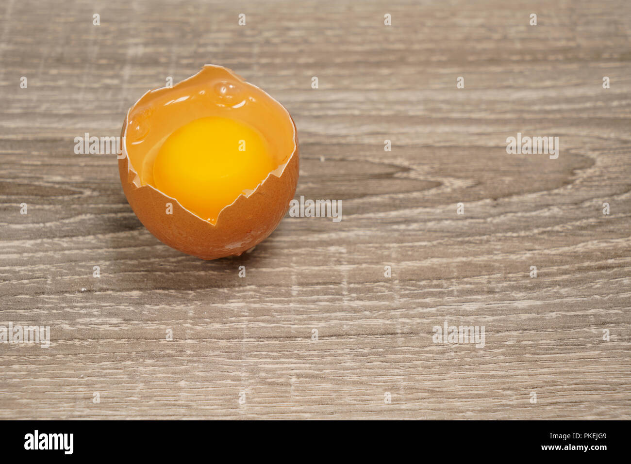 Un oeuf cassé sur une table en bois Banque D'Images