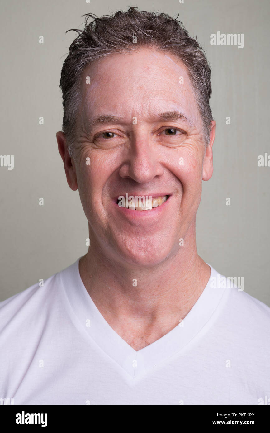 Portrait d'homme mûr avec des cheveux gris contre fond blanc Banque D'Images