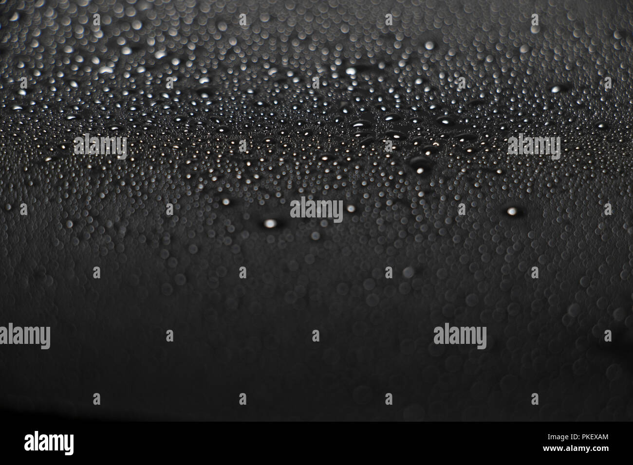 La texture de l'eau sur une surface sombre. Des gouttes de pluie. La vapeur humide de condensation. Le Zen. Banque D'Images