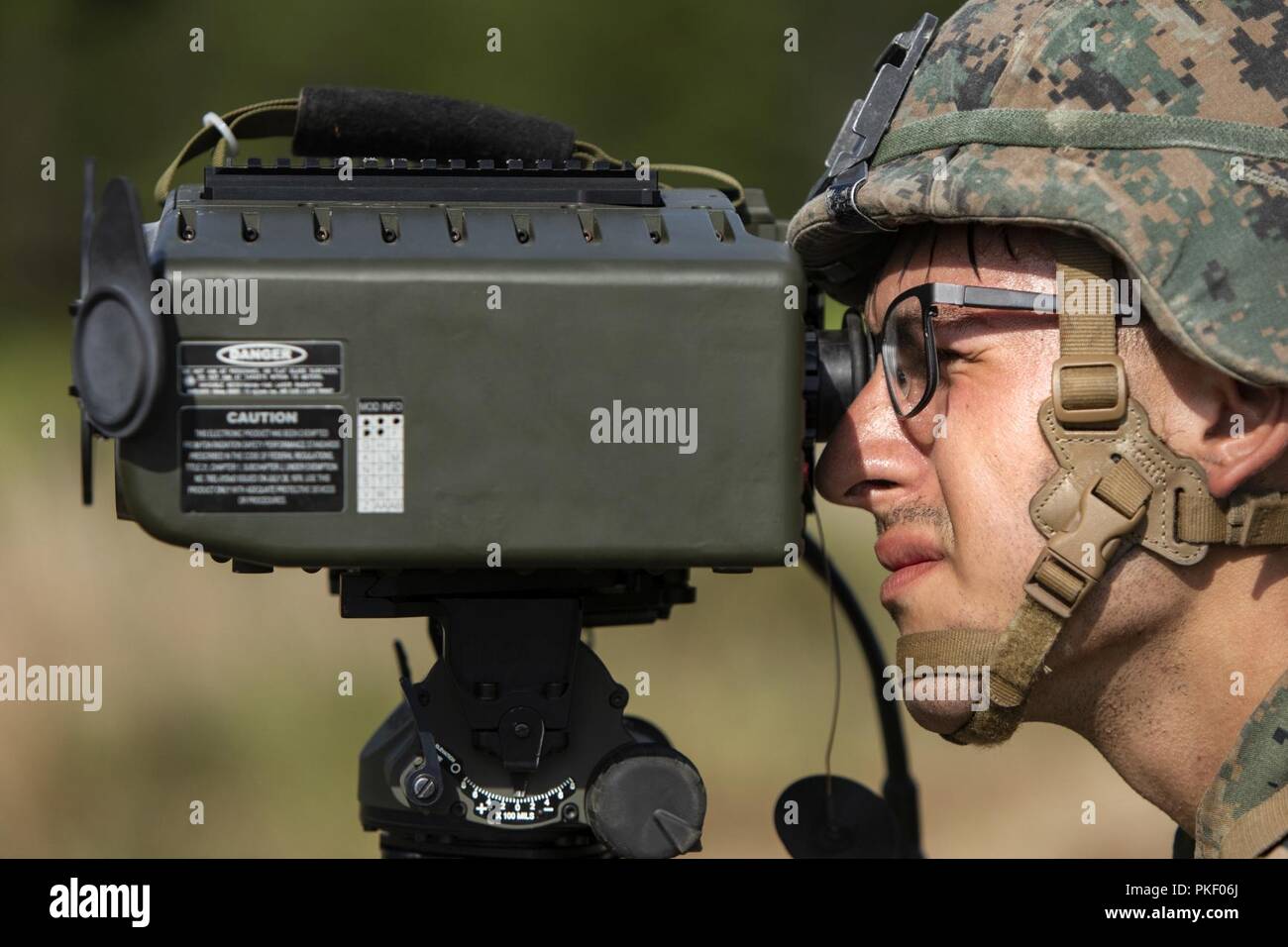 Lance le Cpl. Hunter Castillo, un bataillon mixte d'observation des incendies avec l'équipe d'atterrissage, 1er Bataillon, 2ème Marines, 22e Marine Expeditionary Unit (MEU) regarde à travers un désignateur Laser Télémètre pendant toute une gamme dans le cadre de la 22e MEU déploiement pour l'entraînement à Fort A.P. Hill, VA., 1er août 2018. La gamme admis plusieurs batteries telles que l'artillerie, les mortiers et les aéronefs à voilure fixe de s'entraîner ensemble afin d'améliorer les procédures normales d'exploitation internes en vue de leur prochain déploiement. Banque D'Images