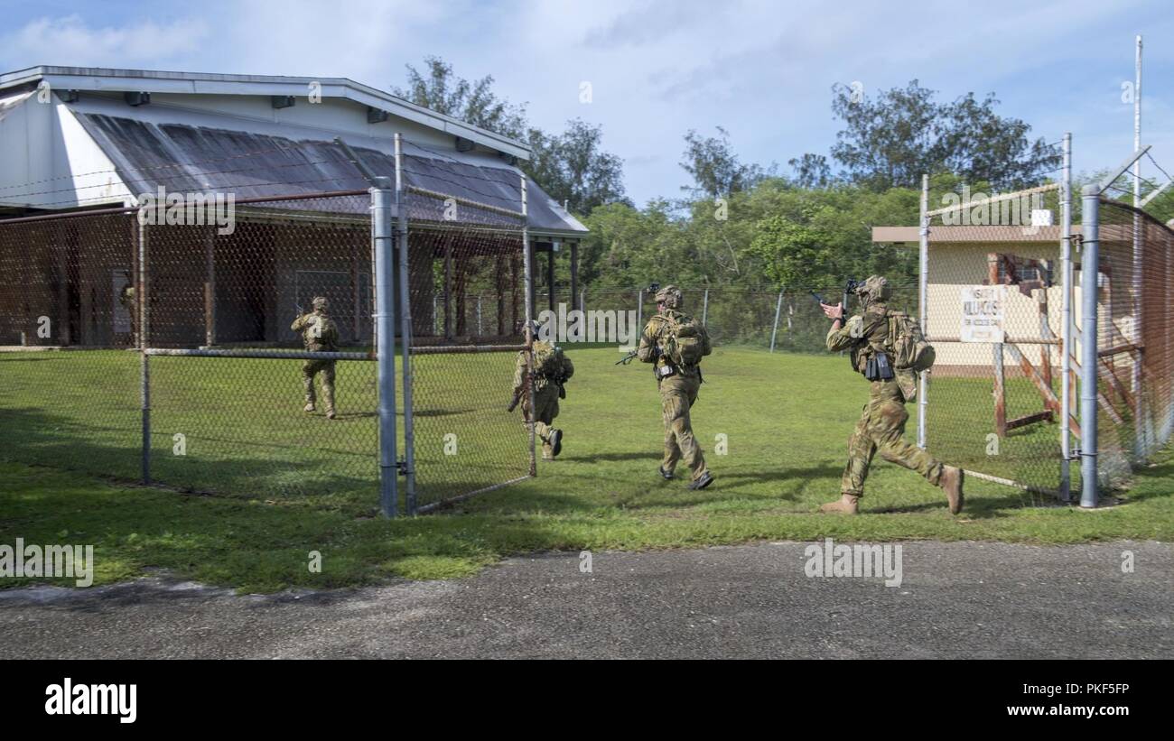 Les soldats de l'armée australienne entrez un kill house pendant la formation au niveau de l'unité 'Pyrocrab' base navale à Guam, le 6 août 2018. Pyrocrab est une bi-niveau de l'unité, une formation qui porte sur le renforcement des relations et de renforcer l'interopérabilité entre les forces de la Marine américaine et australienne. EODMU-5 est attribuée à commandant de la Force 75, la task force expéditionnaire principale responsable de la planification et l'exécution des opérations fluviales côtières, des explosifs et munitions, d'ingénierie et de construction, plongée sous-marine et de construction dans la 7e flotte américaine zone d'opérations. Banque D'Images