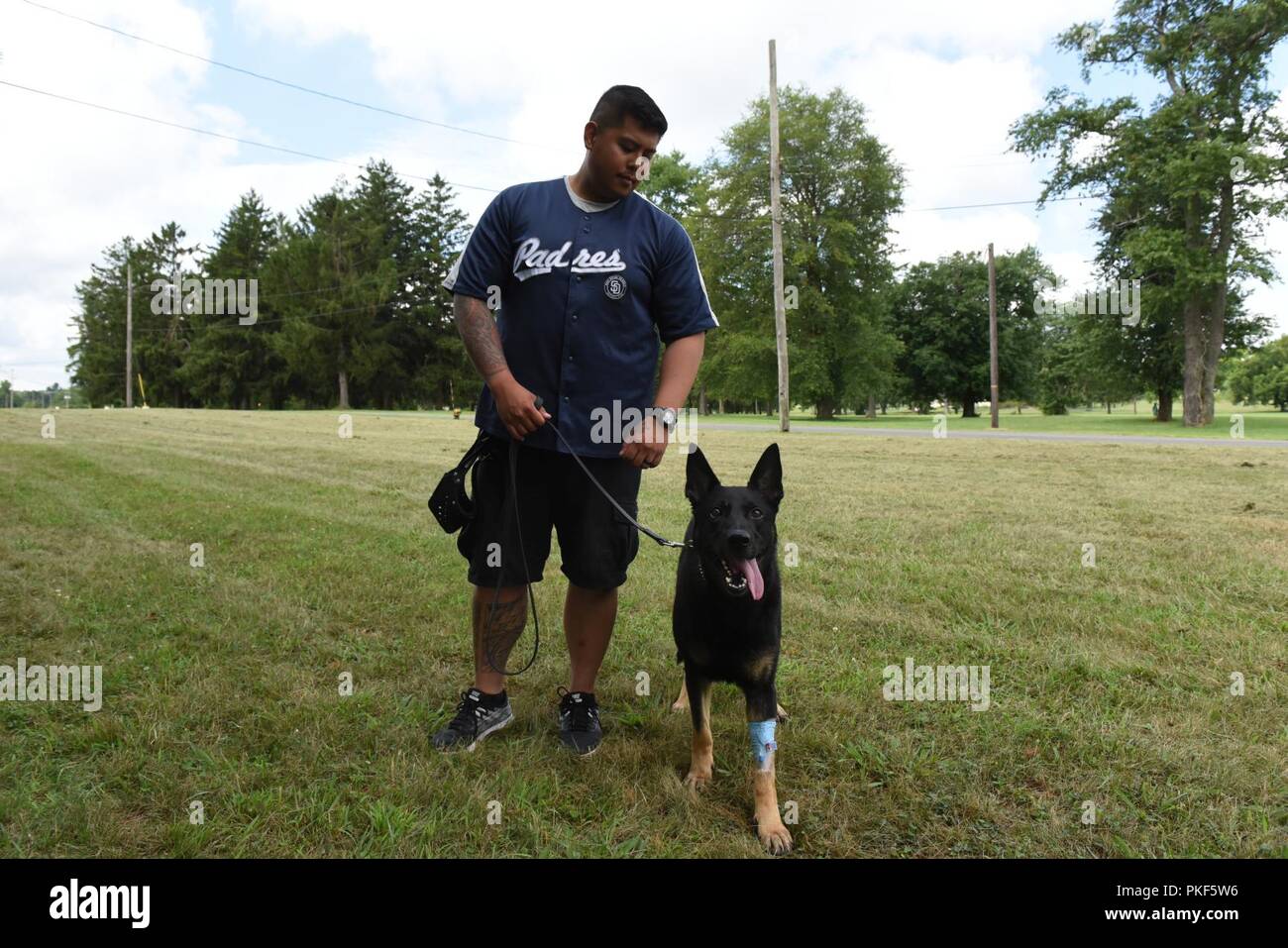 Master-at-Arms 3 Classe Jordanie Sison, 87e Escadron des Forces de sécurité, conducteur de chien de travail militaire et son Ricky MWD, prenez l'air frais après Ricky a reçu un traitement de canal à Joint Base McGuire-Dix-Lakehurst, N.J., le 26 juillet 2018. Ricky était de retour sur ses pieds en quelques minutes de l'sédatifs utilisés dans la procédure disparaît. Banque D'Images