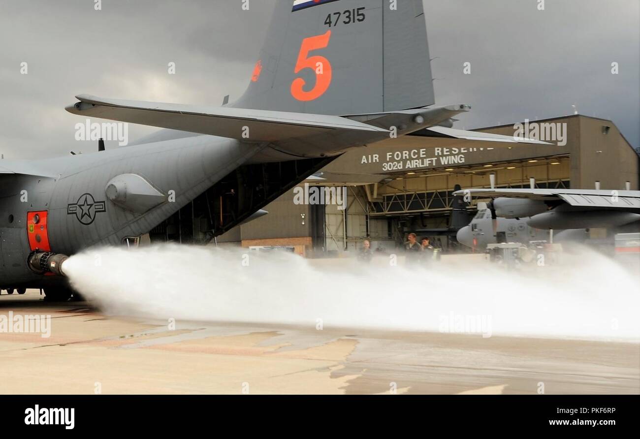 Les arrimeurs affectés à la 302e Airlift Wing mener un essai au feu humide du U.S. Department of Agriculture Forest Service aéroporté modulaire du système de lutte contre l'incendie installés sur l'une de la réserve de l'aile C-130 Hercules à la base aérienne Peterson, le 8 août 2018. L'MAFFS équipée C-130 et son équipage se déploient à la Californie, aujourd'hui, pour soutenir les missions d'extinction des incendies de l'antenne. Banque D'Images