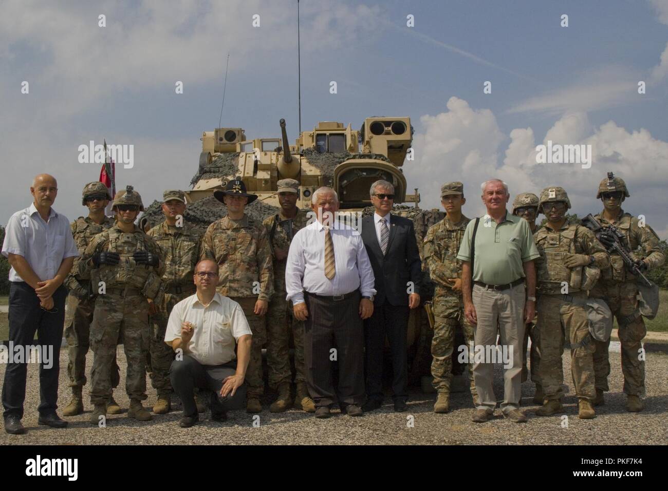 Les Comanches, 1er Escadron, 7e régiment de cavalerie, 1st Armored Brigade Combat Team, 1re Division de cavalerie, et les maires de villes environnantes posent devant un véhicule de combat Bradley M3 au cours d'une journée de formation à l'unité d'observation de la zone centrale de formation à Várpalota, Hongrie, 3 août 2018. Troupe Comanche a invité l'Ambassadeur des États-Unis à la Hongrie David B. Cornstein, les maires des villes voisines de la zone d'entraînement, des soldats hongrois et les médias hongrois pour voir des expositions statiques et des démonstrations de véhicules, armes, équipements et capacités. Banque D'Images