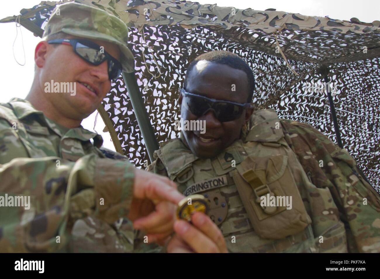 Le colonel de l'armée américaine Donald R. Baker, haut responsable de l'armée / Attaché à la défense des États-Unis à Budapest donne sa pièce de commande du personnel de l'armée américaine le Sgt. Kendall Herrington, le maître canonnier de troupes et les hauts du scoutisme avec Comanche Troop, 1er Escadron, 7e régiment de cavalerie, 1st Armored Brigade Combat Team, 1re Division de cavalerie, au cours d'une journée de formation à l'unité d'observation de la zone centrale de formation à Várpalota, Hongrie, 3 août 2018. Troupe Comanche a invité l'Ambassadeur des États-Unis à la Hongrie David B. Cornstein, les maires des villes voisines de la zone d'entraînement, des soldats hongrois et hongrois local multimédia pour afficher stat Banque D'Images