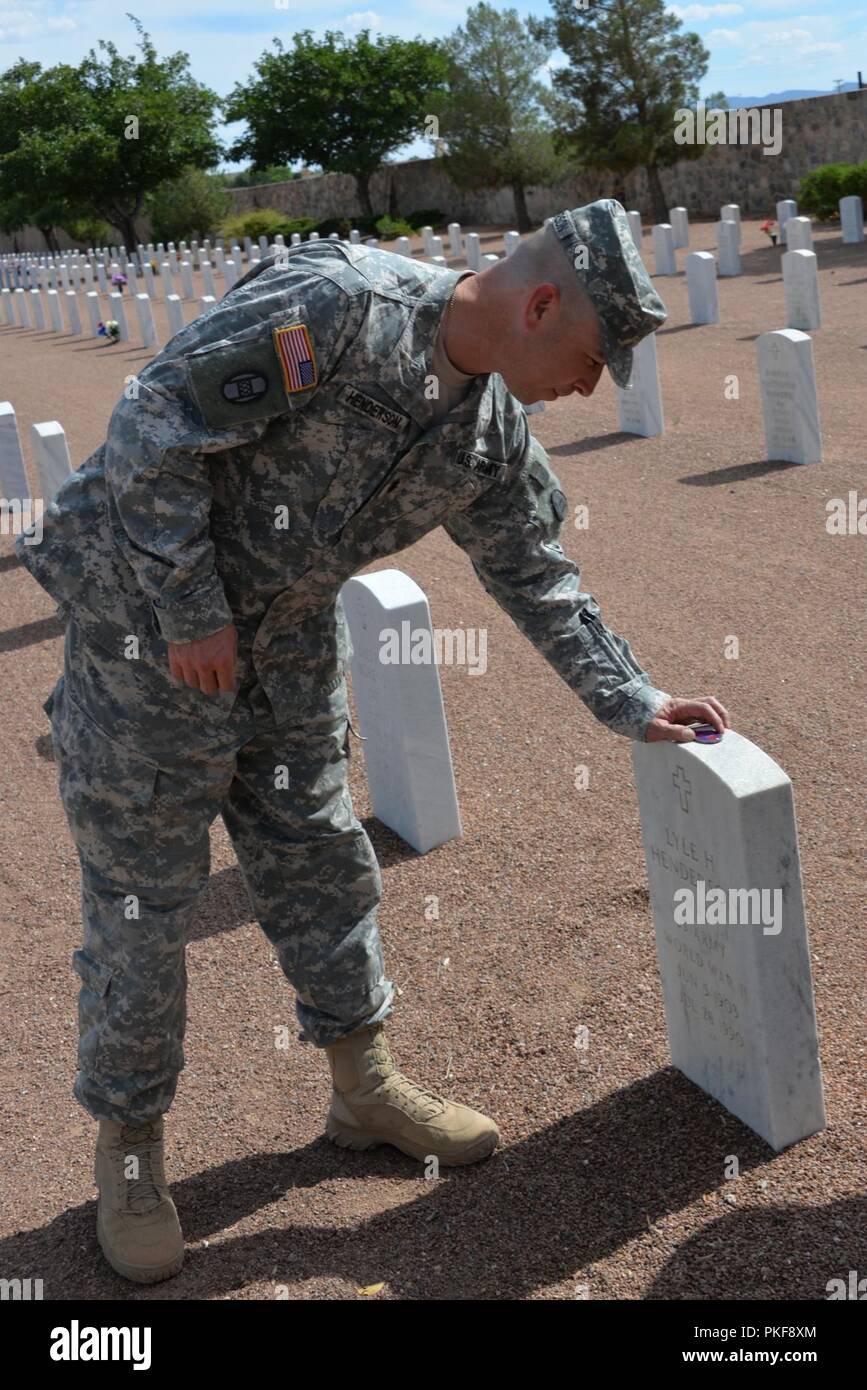 Fort Bliss, Texas - Le Major Patrick Henderson, 236e bataillon du génie de la brigade, commandant de la 30e Brigade blindée lieux une équipe de combat coin sur la pierre tombale de son défunt grand-père, le Major Lyle Henderson à l'issue de sa cérémonie de promotion. Le lieutenant-colonel Henderson, 236e bataillon du génie de la Brigade, le commandant a profité de l'occasion d'être à Ft. Bliss pour la formation d'assurer sa promotion à la tombe de son grand-père, le Major Lyle Henderson qui a servi DANS LA SECONDE GUERRE MONDIALE et est enterré au cimetière national de Bliss FT. Banque D'Images