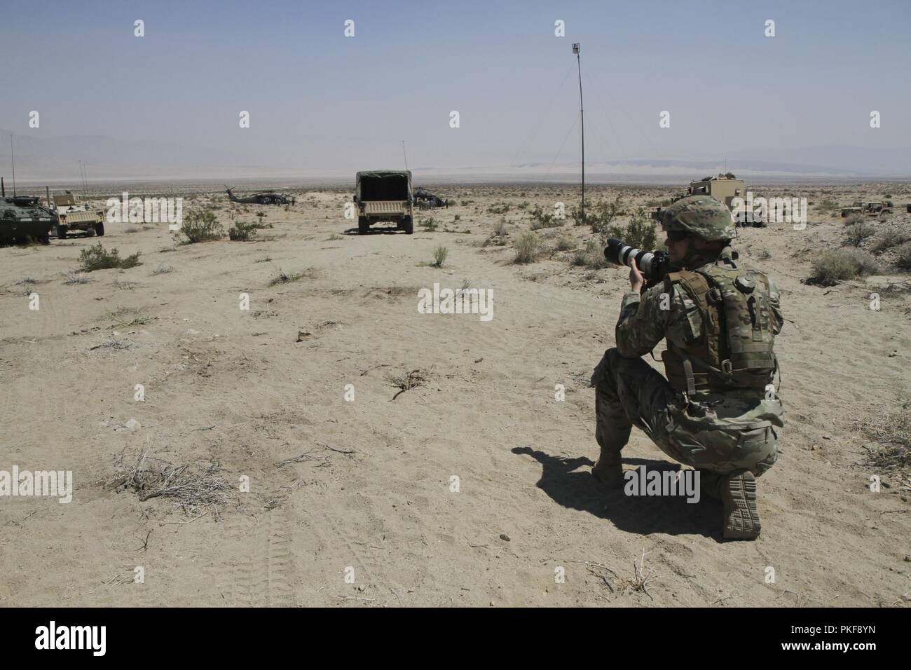 Le s.. Ashley Childress, un spécialiste des affaires publiques avec la 109e Détachement des affaires Public Mobile, 213e groupe d'appui régional, New York Garde nationale prend une photographie de l'hélicoptère UH-60 Blackhawk le 6 août au Centre National d'entraînement, Fort Irwin, ca. La 109ème MPAD a fourni le soutien des affaires publiques lorsque le général Joseph Lengyel, chef, Bureau de la Garde nationale a visité les troupes de la 56e Stryker Brigade Combat Team au NTC. Banque D'Images