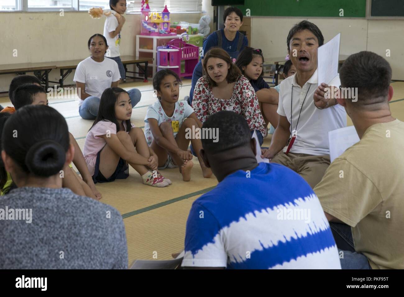 Fusiliers marins et marins avec un bataillon de logistique de combat 31, 31e Marine Expeditionary Unit, enseigner aux enfants locaux anglais Namisato phrases au centre communautaire, Okinawa, Japon, le 9 août 2018. Les relations communautaires événements 31e MEU Marines l'occasion de créer des liens avec les voisins et de contribuer aux communautés autour des installations du Corps des Marines. Banque D'Images