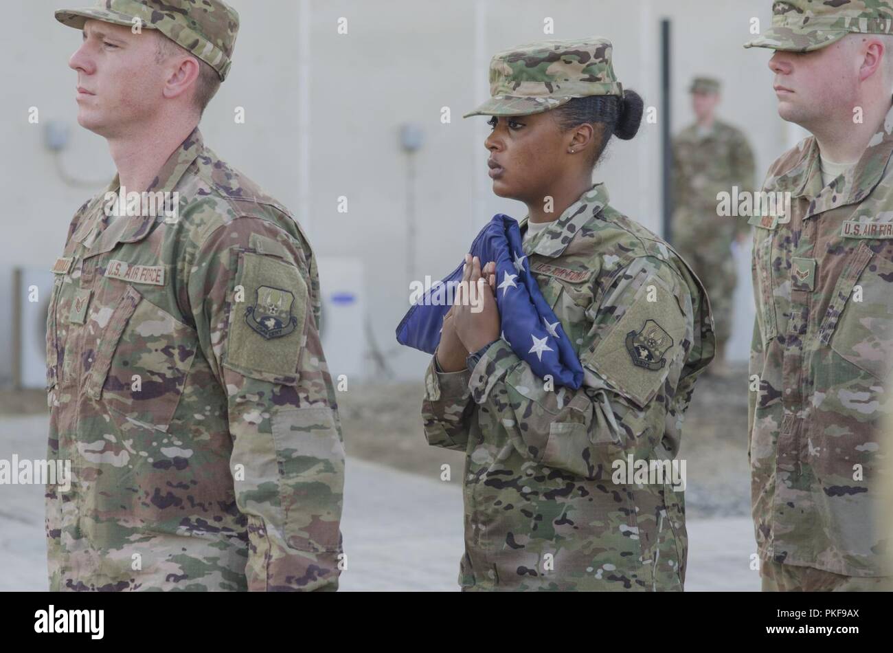 380e Escadre expéditionnaire de la garde d'honneur membres portent le drapeau américain lors d'une retraite cérémonie à la base aérienne d'Al Dhafra aux guerriers tombés au champ d'honneur, le 3 août 2018. La 380e escadre expéditionnaire aérienne est titulaire d'une cérémonie de retraite une fois par mois à l'honneur les guerriers tombés. Banque D'Images