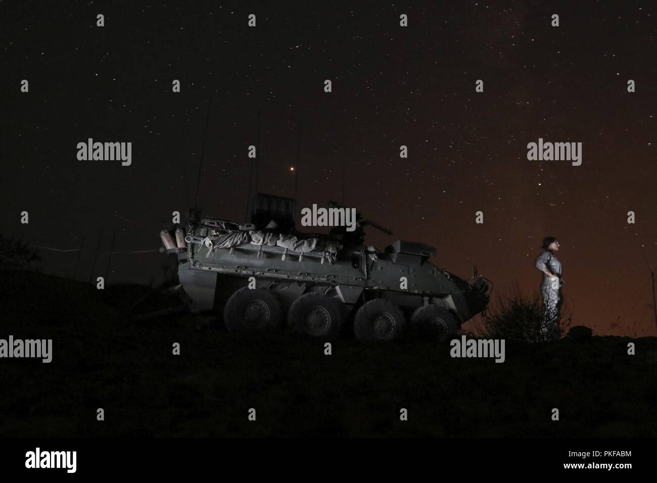 La CPS. Jessica Dzamba, un spécialiste des systèmes de soutien du signal, assigné à la société C, 103e Brigade, Catherine Flaesch-mougin Ingénieur 56e Stryker Brigade Combat Team, New Jersey Army National Guard, prend un peu de temps pour admirer le ciel nocturne du désert en face d'elle, Stryker 'Tammy.' Banque D'Images