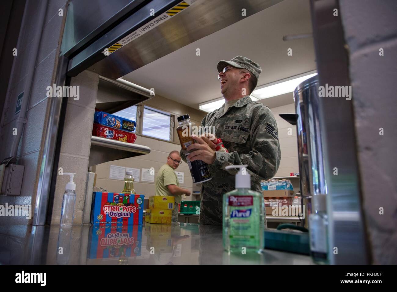Le sergent de l'US Air Force. Nick Hochmuth, une cuisine superviseur affecté à la 109e Airlift Wing, New York Air National Guard, réagit à une blague d'un autre aviateur à la Mitchell Pauole Centre communautaire à Molokai, Hi, le 11 août, 2018. Soins Tropic 2018 Maui County Medical fournit des troupes et du personnel de soutien pratique à la formation de préparation pour préparer de futurs déploiements tout en offrant des avantages directs et durables pour la population de Maui, Molokai et Lanai. Banque D'Images