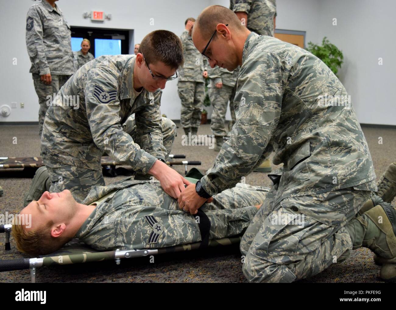 Les membres du groupe médical, 185e Escadre de ravitaillement en vol, Sioux City, IA, participer à l'exercice dans la tempête Savannah Savannah Air National Guard Base en Géorgie. Le Capitaine Paul Niles et le sergent. Paul Murillo en sangle aviateur Senior Paul Wurth sur la civière pliable pour le transport au cours de la formation de la litière. Banque D'Images