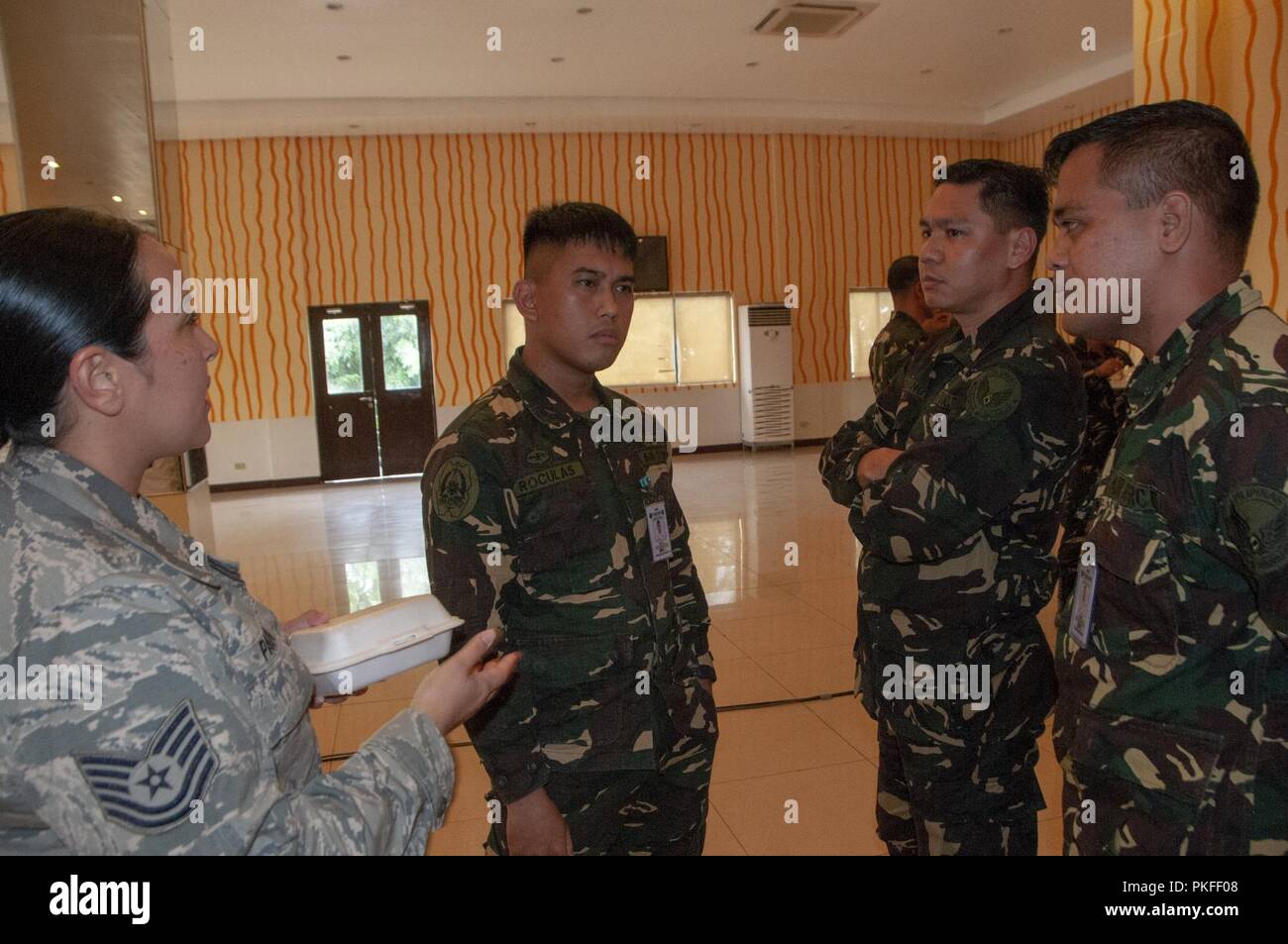 Tech. Le Sgt. Franchesa Pau'u, 169e Escadron de défense aérienne contrôleur des armes des entretiens avec un groupe d'aviateurs de l'Armée de l'Air Philippine, le 6 août 2018, Villamor Air Base, Manille, Philippines. Pau'u et d'autres membres de la California Air National Guard prenant part à un échange d'experts en la matière avec le PAF dans le cadre d'un programme de partenariat de l'état de la Garde nationale de l'engagement. Banque D'Images