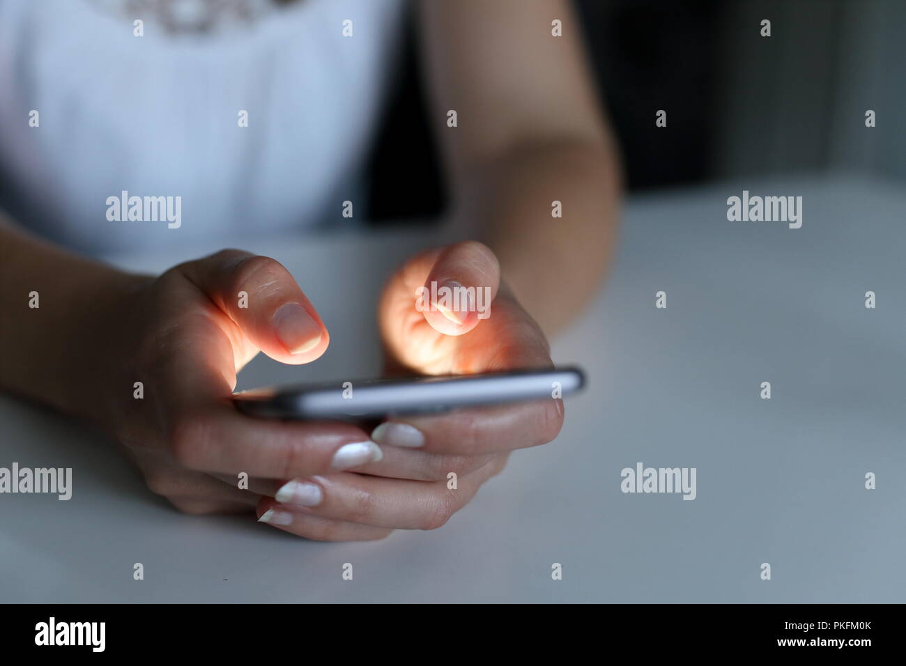 Une femme avec le smartphone de nuit Banque D'Images