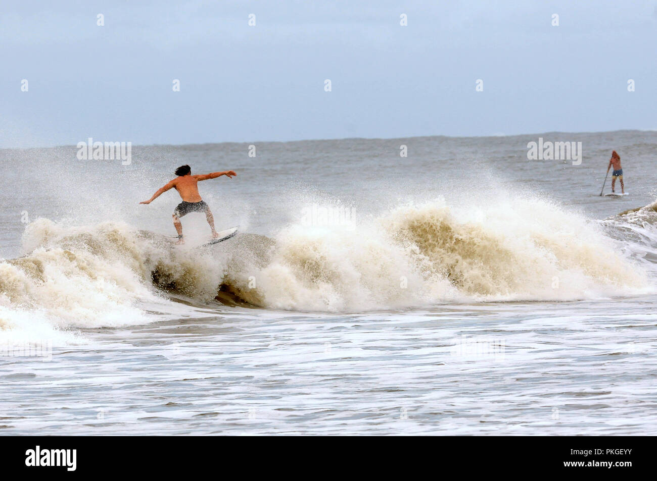 La Caroline du Sud, USA. 13 septembre 2018 - Folly Beach, South Carolina, United States - manèges d'un surfer les vagues à Folly Beach, Caroline du Sud le 13 septembre 2018 que l'ouragan Florence fait son chemin vers les côtes de la Caroline du Nord et du Sud. (Paul Hennessy/Alamy) Crédit : Paul Hennessy/Alamy Live News Banque D'Images