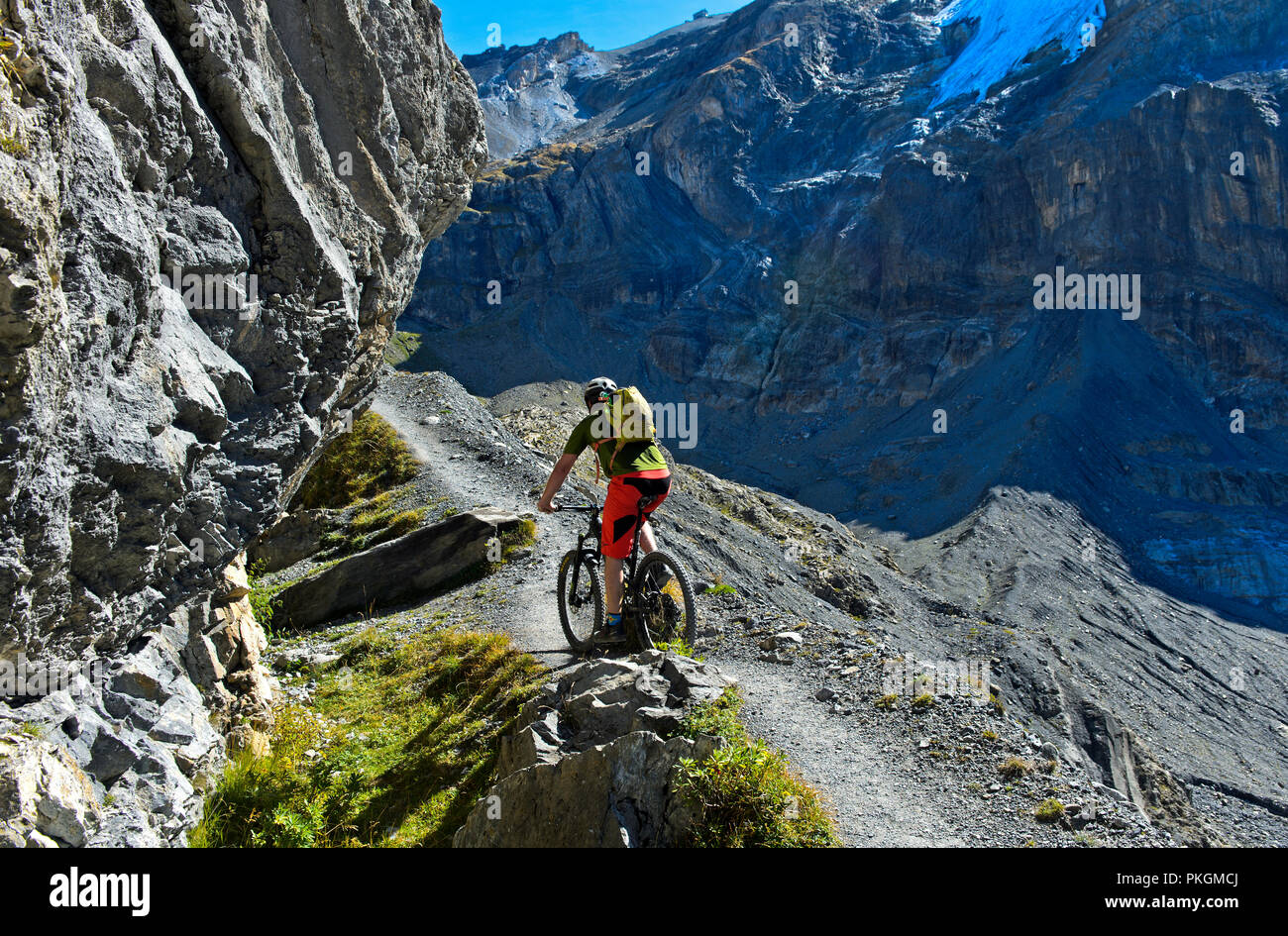 Un coureur de vélo de montagne sur une voie unique sur la moraine latérale du glacier Blüemlisalpgletscher, Kandersteg, Suisse Banque D'Images