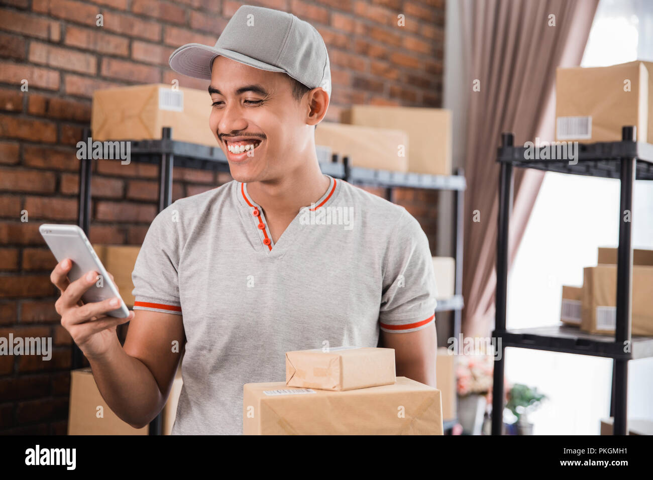 Homme avec un paquet holding smartphone Banque D'Images