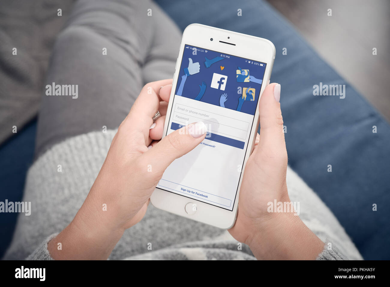 Kiev, Ukraine - le 24 janvier 2018 : femme commencer à utiliser Facebook app sur Apple iPhone 8 Plus à la maison. Facebook est un service en ligne de médias sociaux pour micro Banque D'Images