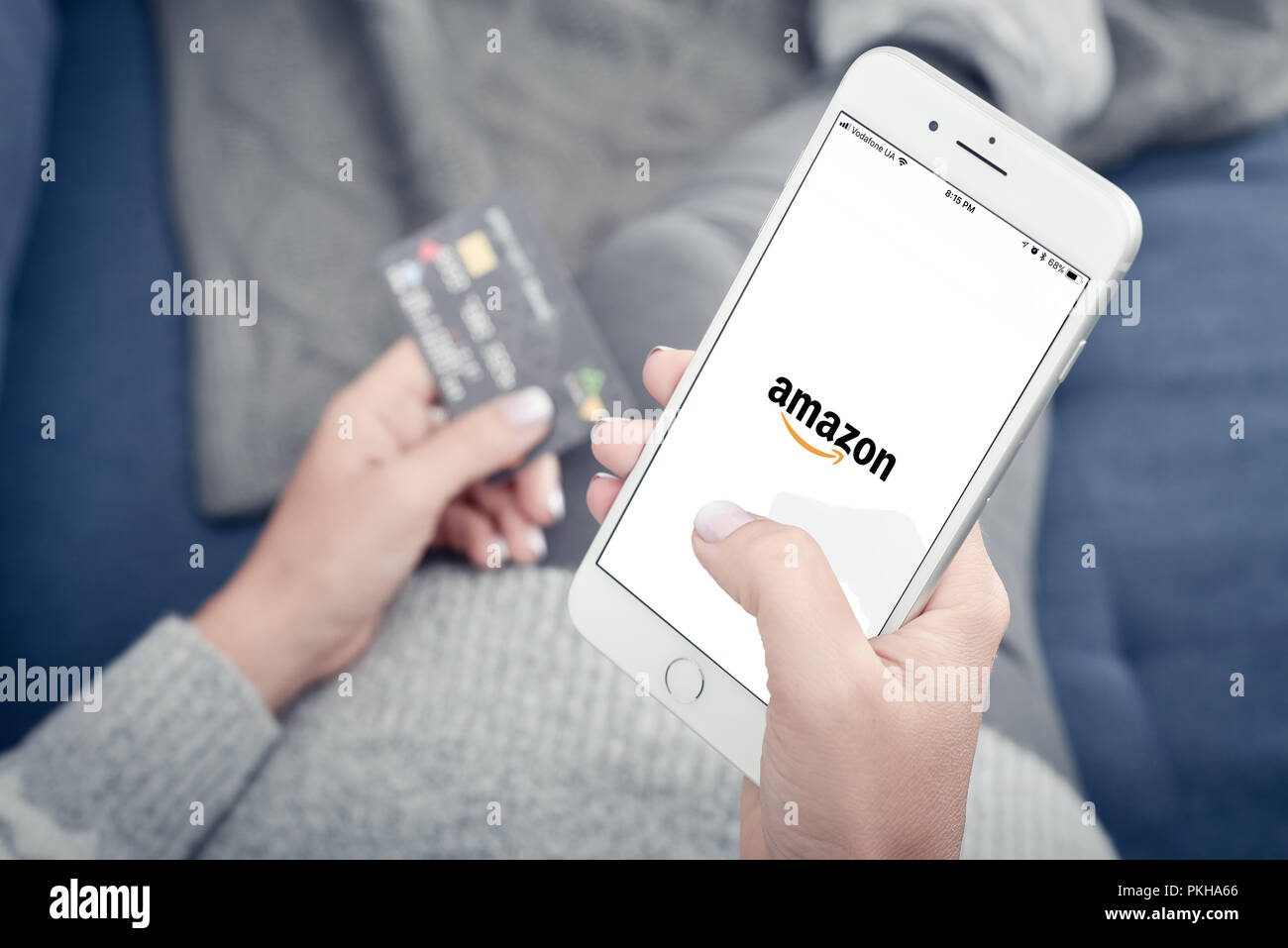 Kiev, Ukraine - le 24 janvier 2018 : Woman holding Apple Iphone 8 plus avec Amazon de chargement mobile app à la maison libre. Banque D'Images