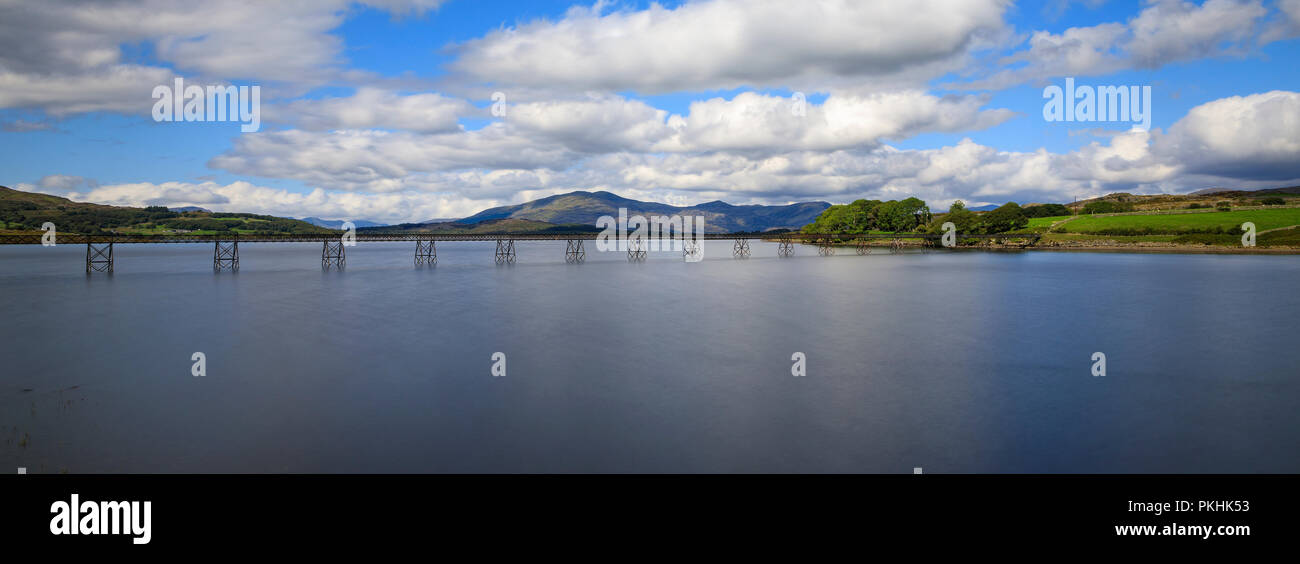 Une longue exposition de Trawsfynydd Lake dans le sud de Galles, au Royaume-Uni. Ciel bleu, les nuages prenant en. Banque D'Images