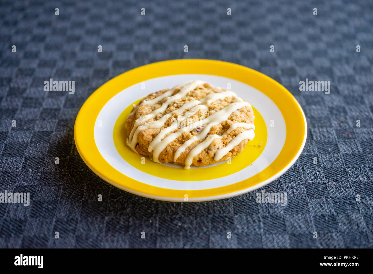 Biscuit crumble d'avoine garni de yaourt présenté sur une plaque jaune colorée sur fond noir, Angleterre, Royaume-Uni Banque D'Images