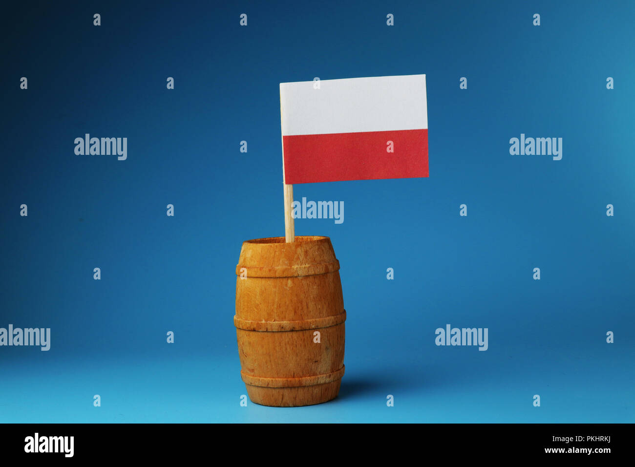 Un drapeau national de la Pologne le bâton en bois de tonneau en bois sur fond bleu Banque D'Images