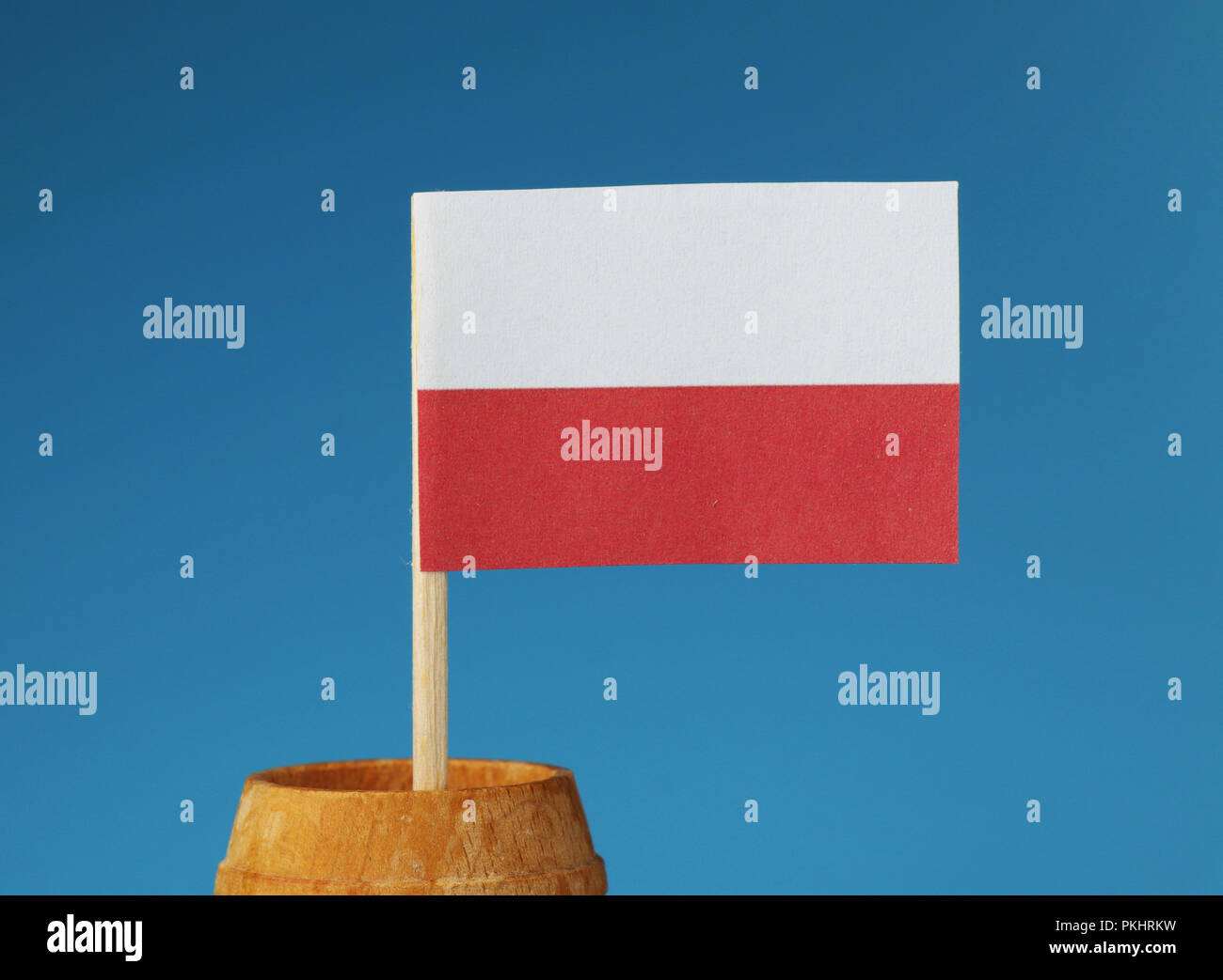 Un détail sur le drapeau national de la Pologne le bâton en bois de tonneau en bois sur fond bleu Banque D'Images