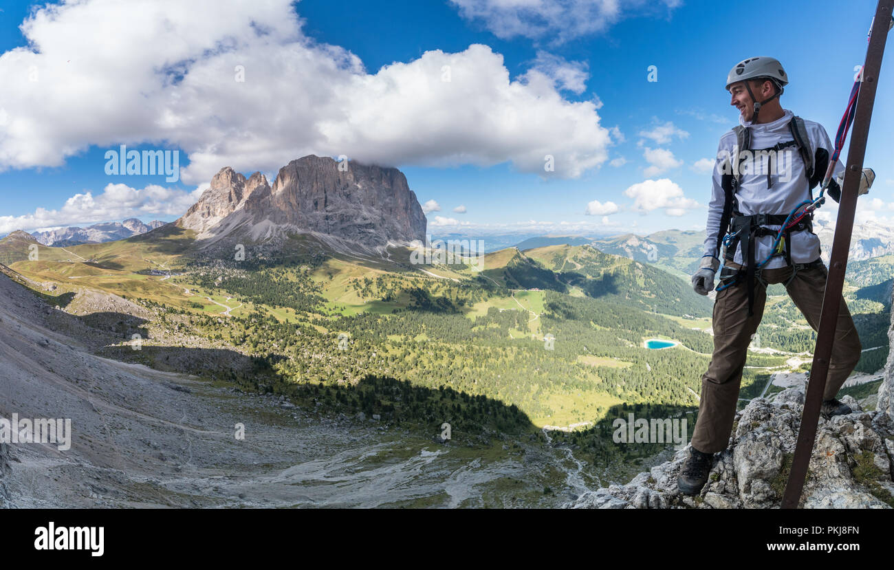Young attractive male d'alpiniste dans les Dolomites de l'Italie avec une magnifique vue panoramique de la Passo Sella et Langkofel Banque D'Images